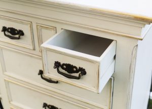 distressed chest of drawers with black handles and sanded edges